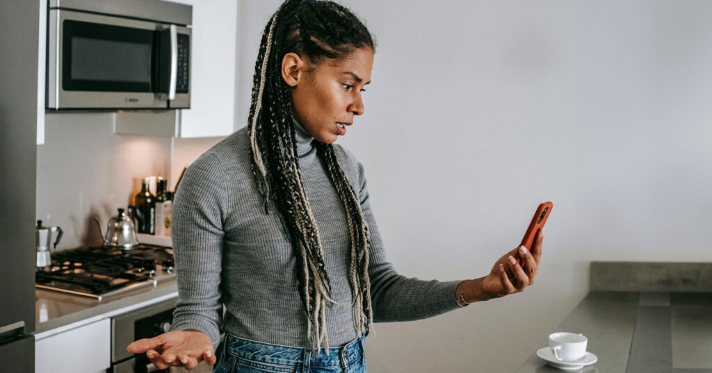 Pessoa com expressão de frustração olhando para o celular após realizar um Pix errado, demonstrando insatisfação e preocupação com o erro financeiro.