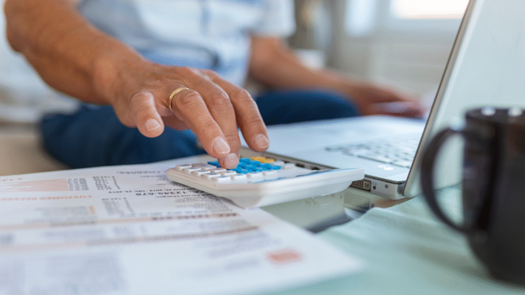 Homem usando calculadora para calcular investimentos e entender o impacto da taxa CDI no seu dinheiro.